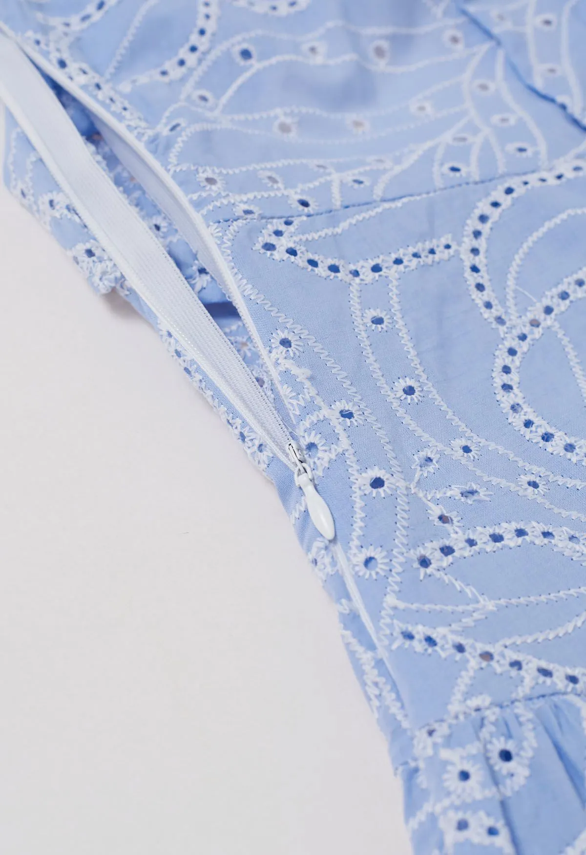 Robe mi-longue à feuilles et œillets brodés au dos et découpe